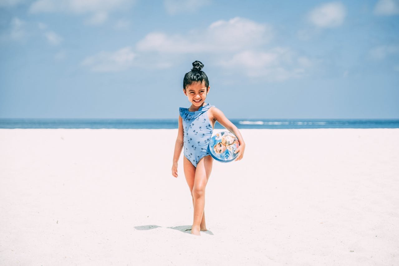 Happy child playing with a ball on a sunny Aruba beach. Perfect summer day.